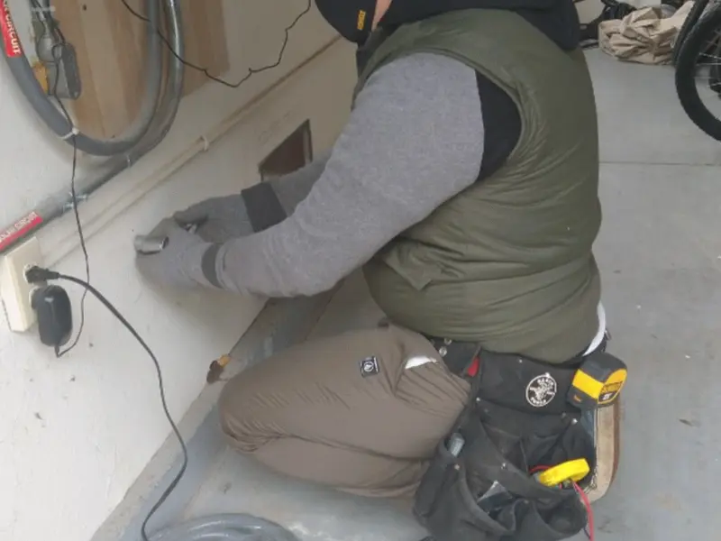 Electrician performing outlet wiring in a Tamarac garage